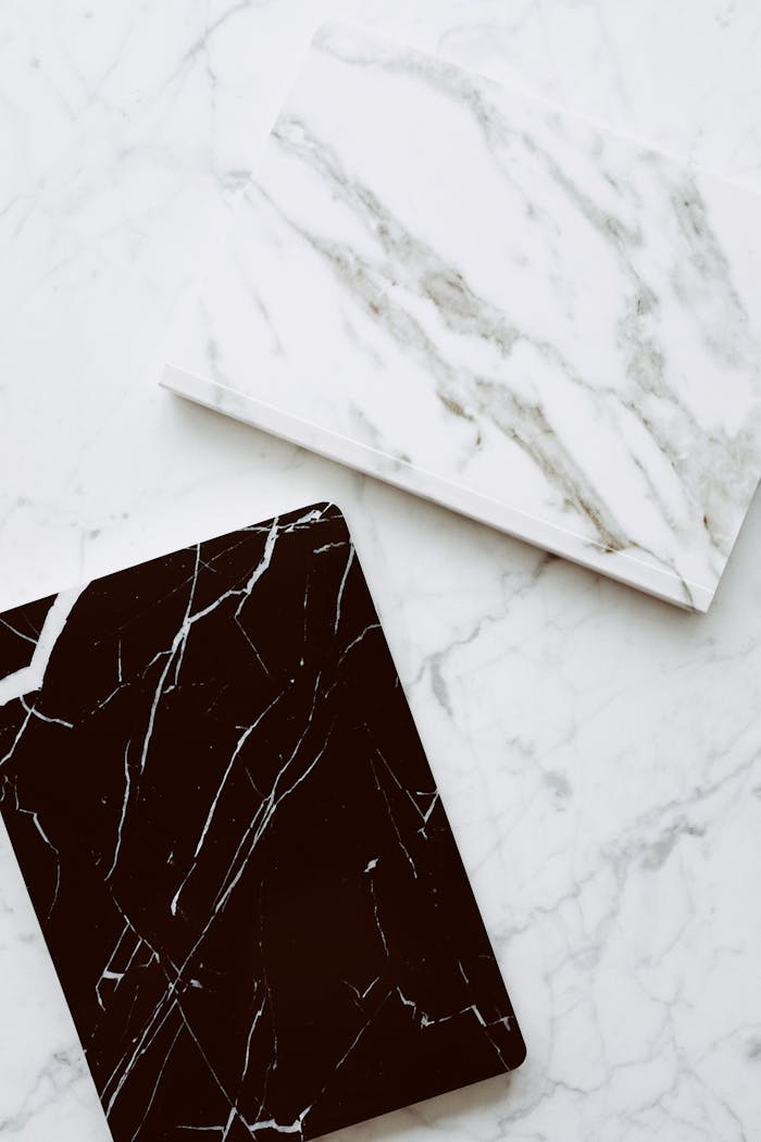 High-quality close-up of contrasting white and black marble tiles on a smooth surface.
